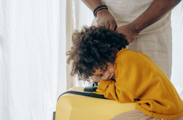 A young girl climbing a suitcase